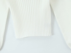 Vue détaillée de la texture du tricot blanc côtelé et de l'ourlet élastique du haut en maille