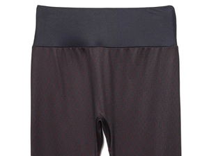 Gros plan sur un legging taille haute au motif géométrique de losanges rouge et gris