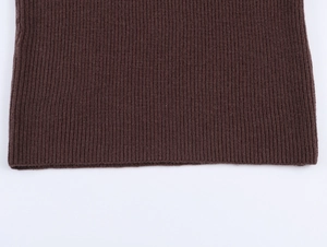 Detailed close-up of dark brown ribbed knit hem and texture on long sleeve sweater
