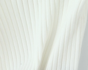 Gros plan sur la texture en tricot côtelé blanc d'un pull ample à manches longues