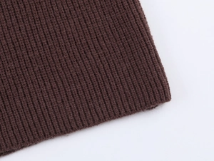 Detailed close-up of dark brown ribbed knit sweater cuff showing thick texture and stitching