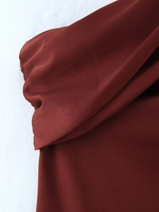 Detail shot of the deep burgundy chiffon fabric with elegant drapes and soft textures