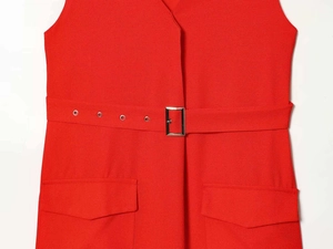 Détail d'une robe rouge à col en V avec ceinture à boucle argentée et poches cargo