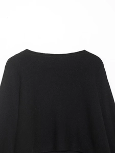 Détail d'un pull en maille noire avec encolure large et texture de tricot fine