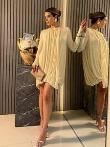 Vue détaillée d'une élégante robe courte beige plissée de style cape sur un mannequin