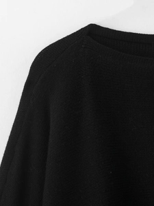 Gros plan du col rond et des détails de tricot sur ce pull noir pour l'automne et l'hiver