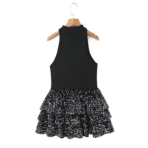 Close-up of sparkling sequin tiered skirt and sleeveless black bodice on a hanger