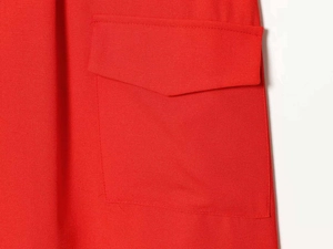 Gros plan détaillé d'une poche à rabat rouge sur une robe sans manches en tissu texturé