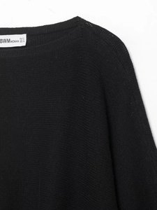 Gros plan sur l'encolure et l'étiquette de marque d'un pull en maille noire