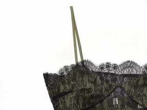 Detail of dark green satin top with fine black eyelash lace trim and delicate straps