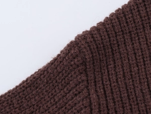 Detailed close-up of dark brown rib-knit sweater fabric showing soft texture and quality