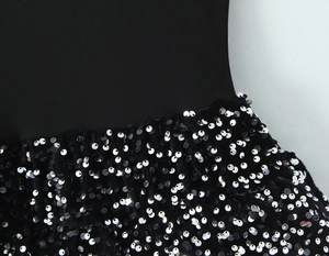 Detail of waist stitching between smooth black knit fabric and shiny silver sequins