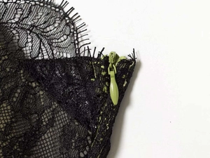 Detail of delicate black eyelash lace over contrast green lining with invisible zipper