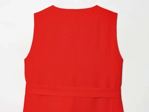 Détail de la robe rouge sans manches avec tissu texturé et coutures soignées à la taille