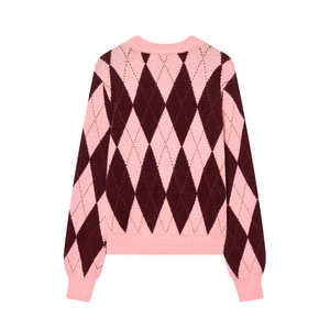 Close-up of pink and brown argyle knit sweater with detailed ribbed cuffs and texture
