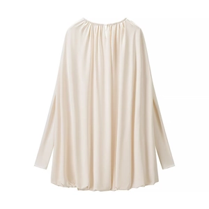 Détail macro d'une blouse en satin blanc crème avec col plissé et drapé élégant