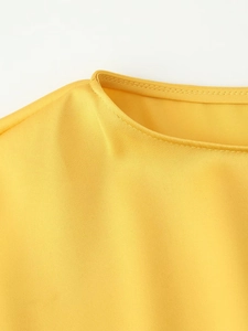 Detailed view of smooth round neckline on vibrant yellow satin midi dress with premium stitching