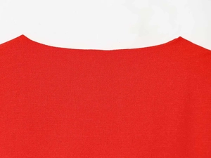 Détail du col d'une robe rouge sans manches montrant la texture fine du tissu tissé