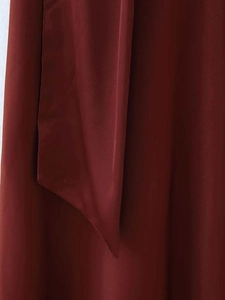 Détail de la robe en satin bordeaux montrant les coutures fines et la texture fluide du tissu
