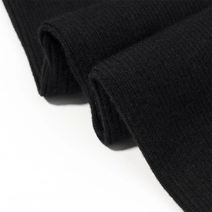 Detailed close-up of premium black ribbed knit fabric showing texture and elastic weave