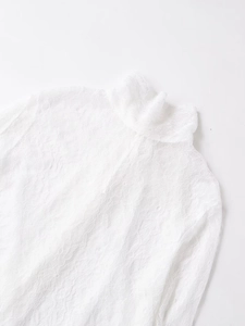 Dettaglio dell'elegante trama di pizzo floreale bianco e del design a collo alto