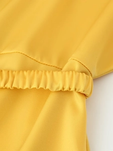 Detail of mango yellow satin dress showing elastic pleated waist and fine stitching
