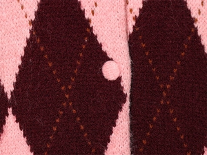 Detailed close-up of pink and burgundy argyle knit pattern and fabric covered button