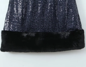 Detail van marineblauwe lovertjes en zwarte imitatiebontrand op een mouwloze jurk