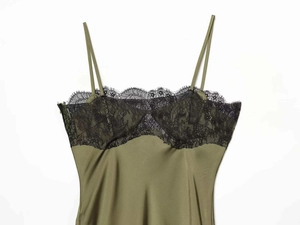 Detail of olive green satin dress featuring black eyelash lace and thin shoulder straps