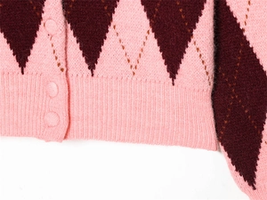 Detailed view of pink and burgundy diamond pattern cardigan with matching buttons