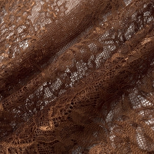 Dettaglio macro del pizzo floreale bronzo con intricati motivi a rete e lucentezza setosa