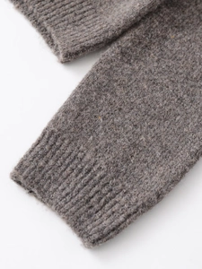 Dettaglio del polsino del cardigan in maglia grigia con morbida trama in lana calda