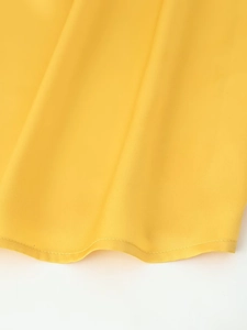 Close-up of bright yellow midi dress fabric showing high-quality hem and smooth texture