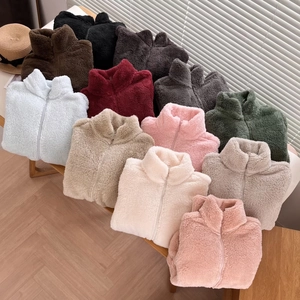 Selection of colorful zip-up fleece jackets in ten shades on a rustic wooden bench