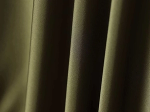 Detailed close-up showing the textured olive green fabric with soft vertical pleats