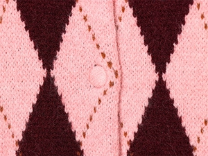 Macro shot of argyle knit pattern and fabric covered button on pink sweater