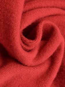 Makroaufnahme von leuchtend rotem Strickstoff mit weicher Wollstruktur und feiner Webart