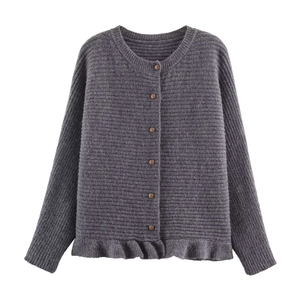 Detailed macro view of the dark grey knitted cardigan featuring a ruffled hem and buttons