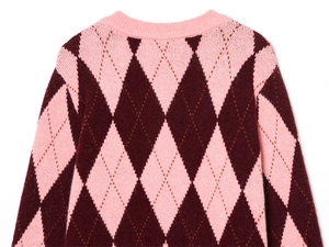 Close-up of pink and deep red argyle knit sweater with detailed diamond pattern texture