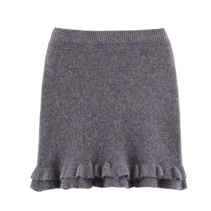 Detail of dark grey knitted mini skirt showing double-layered ruffle hem and cozy wool texture