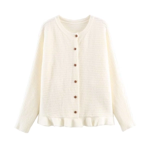 Close-up of cream ruffled hem knit cardigan with contrasting dark brown buttons