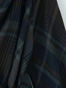 Détail du tissu à carreaux foncés présentant des textures bleu marine, olive et marron