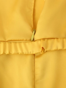 Detailed macro view of yellow satin midi dress featuring a seamless concealed zipper