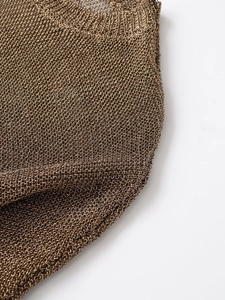 Macro detail of bronze metallic mesh fabric showing intricate knit texture and shine
