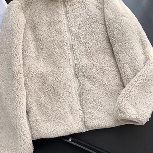 Close-up of beige fleece jacket showing soft texture and full zipper fastener