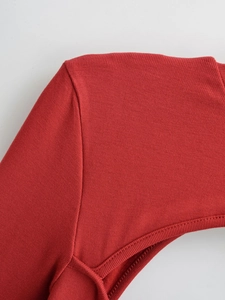 Makroaufnahme des roten Rippstrickkleids zeigt hochwertige Nähte und Stoffstruktur