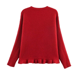 Detail of red knit sweater with ruffle hem and textured vertical ribbed pattern
