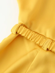 Detail of waist design on bright yellow satin midi dress with elastic pleated texture