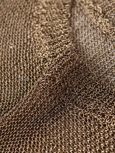 Close-up of metallic mesh fabric detail in antique gold with intricate woven pattern