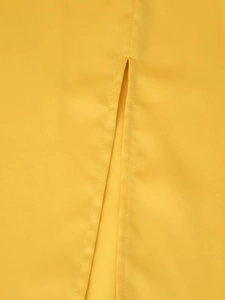 Detailed view of the side slit and fine stitching on a bright yellow midi dress